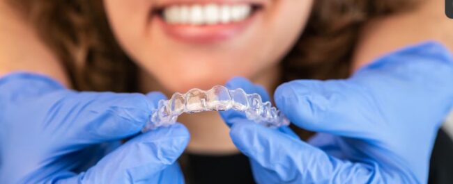 Woman using Invisalign retainer for Orthodontic Aftercare